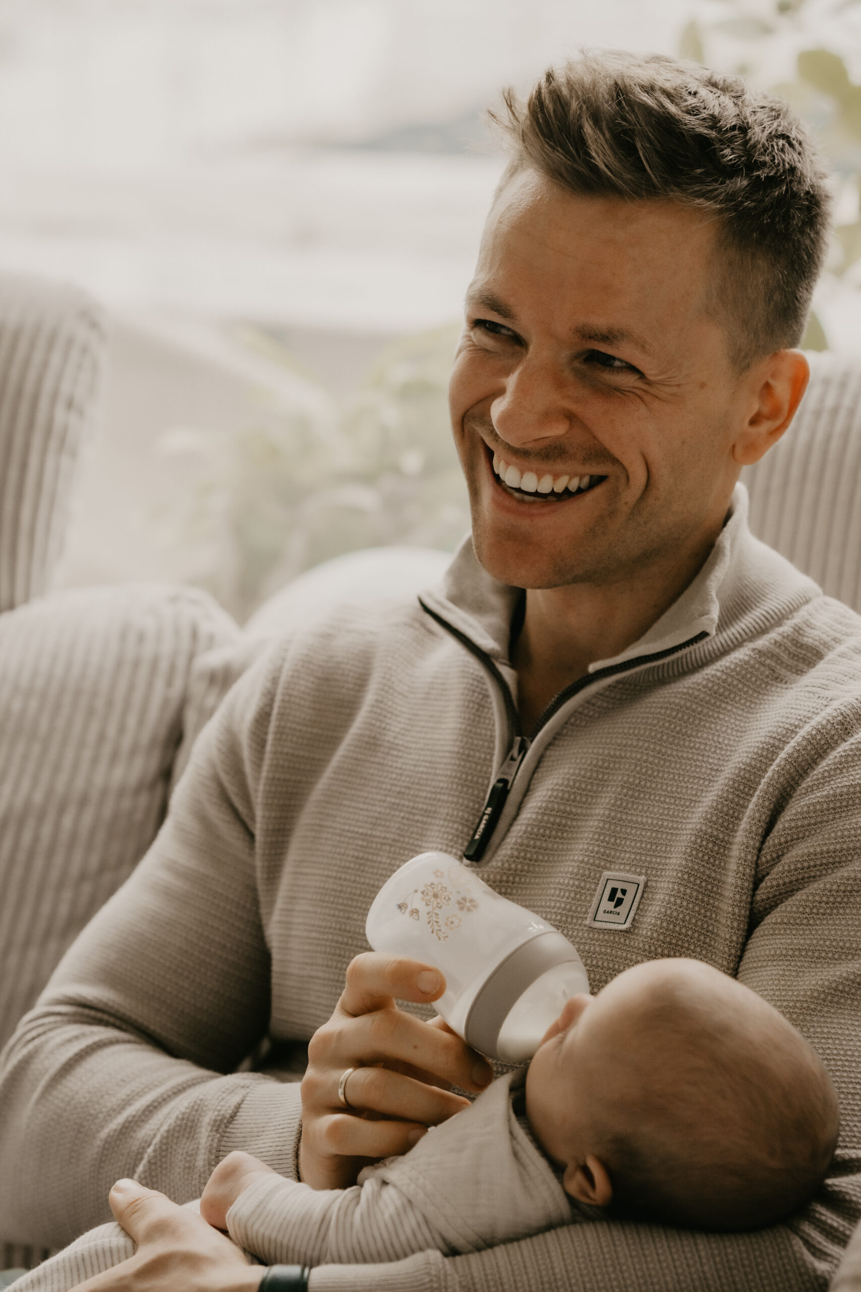 Vater gibt seinem neugeborenen Baby ein Fläschen