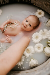 Neugebornes Baby  badet in einem Blütenbad