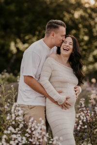 Schwanger mit ihrem Partner, er streichelt den Baabybauch